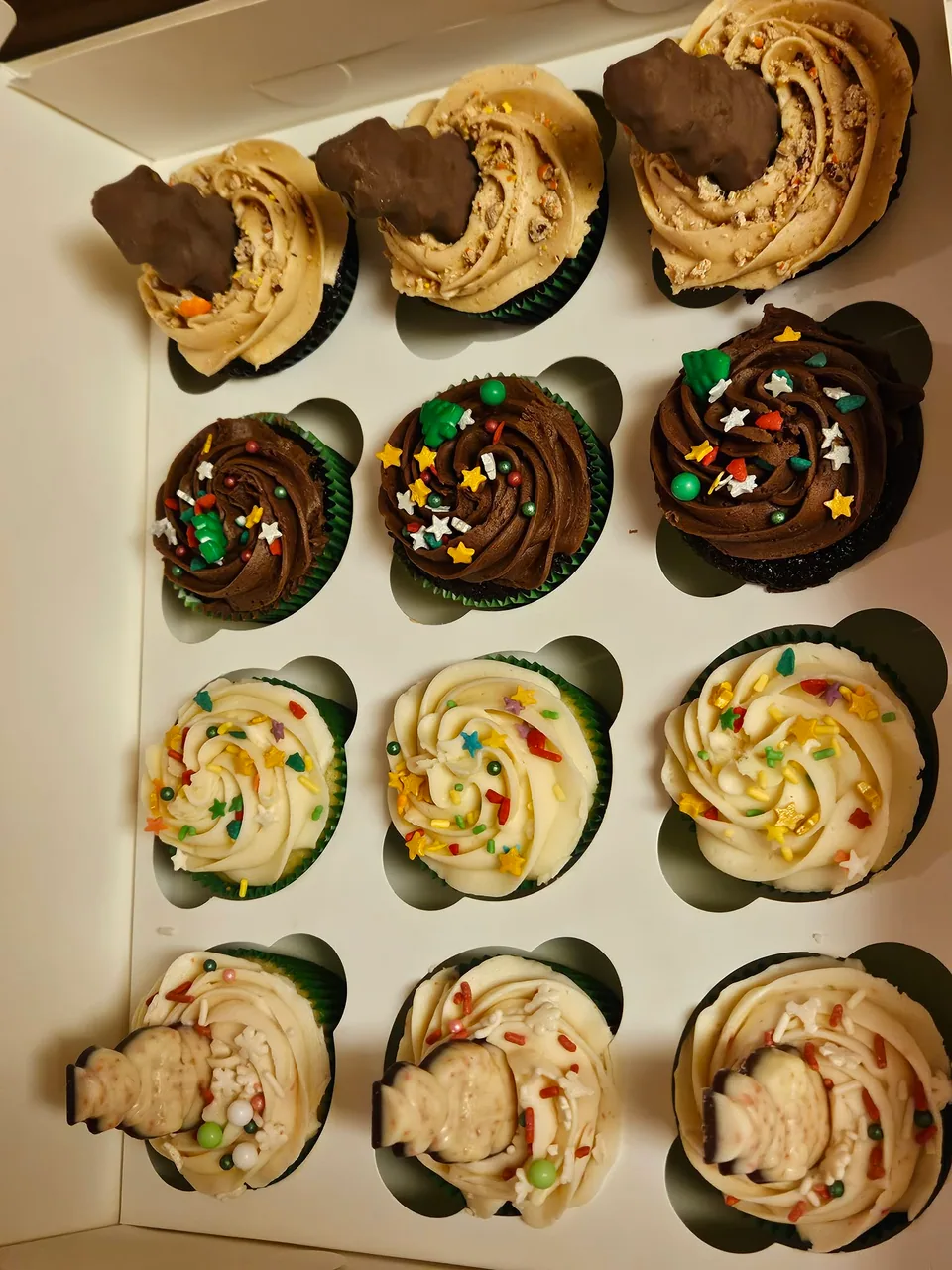 Assorted cupcakes with several piped frosting styles and toppings