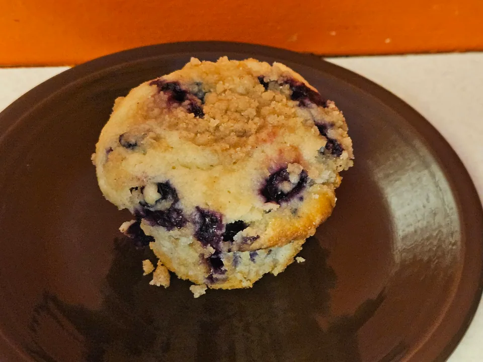 Scratch-made muffin with visible blueberries on a plate