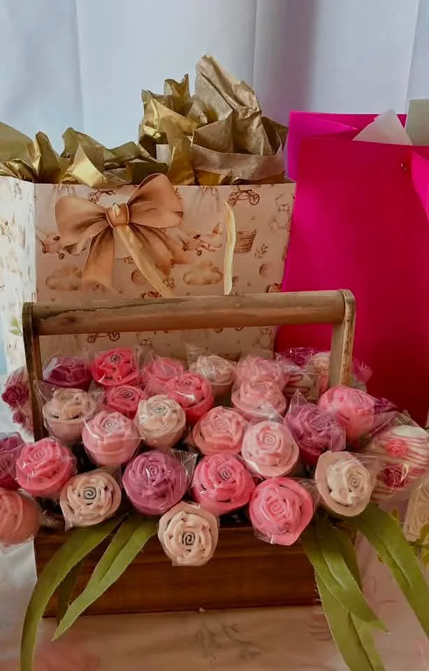 Decorative display filled with pink cake pops and wrapped treats