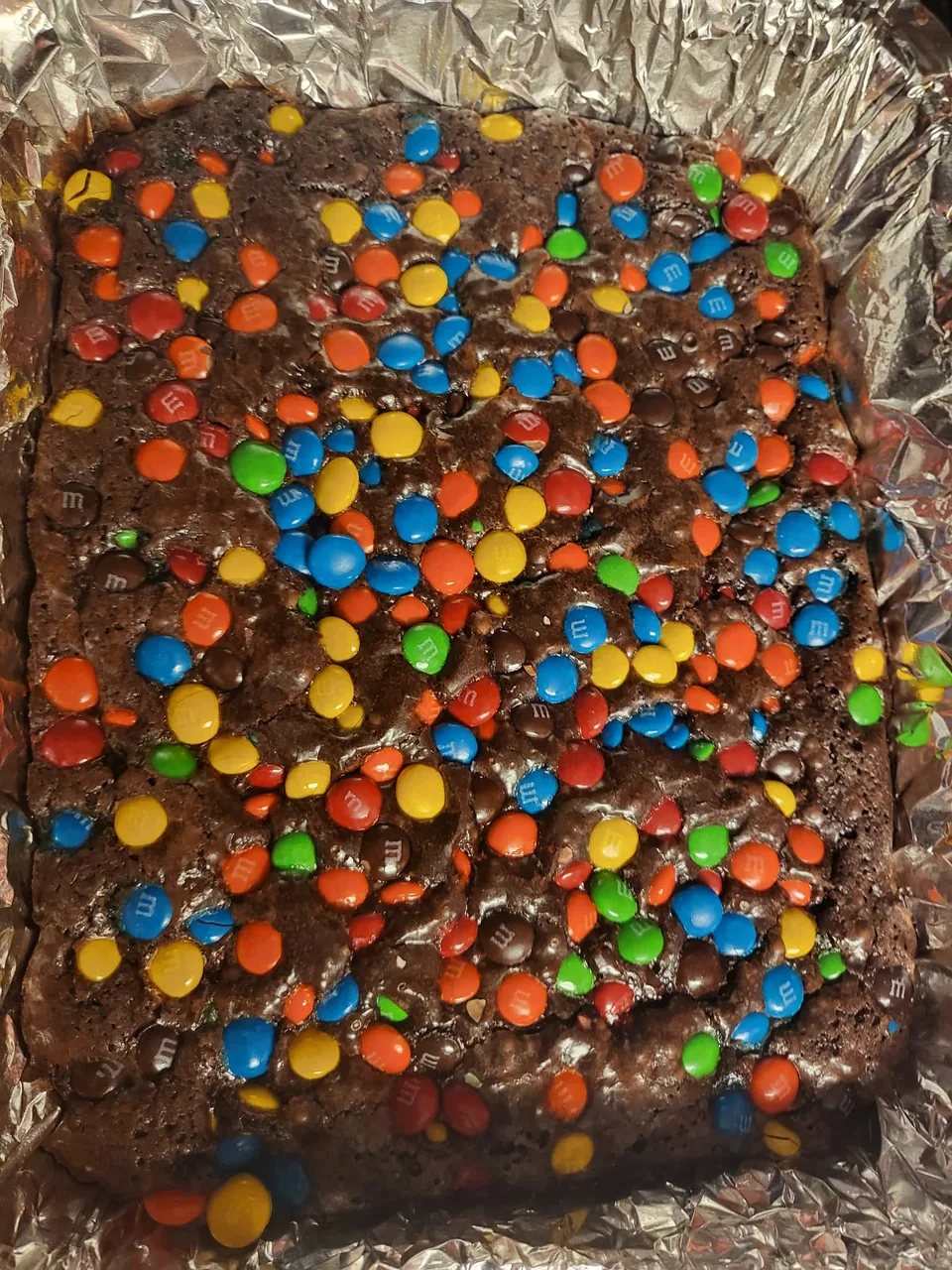 Pan of chocolate brownies topped with colorful candy pieces