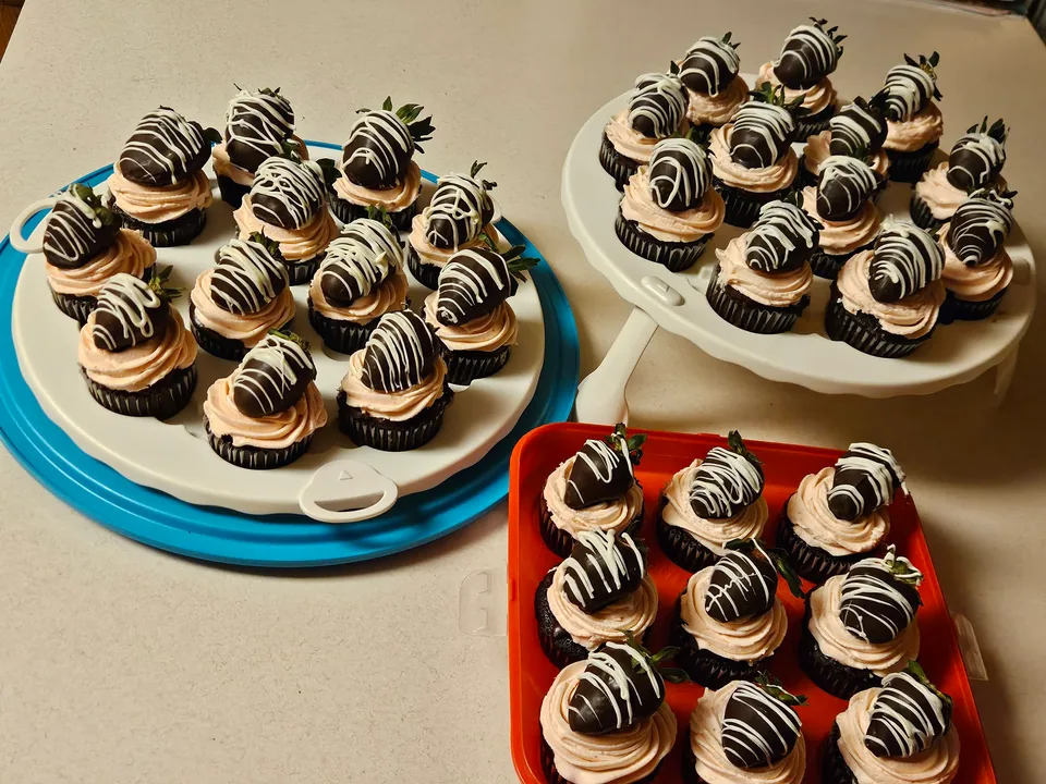 Display of chocolate covered strawberry cupcakes arranged on serving trays