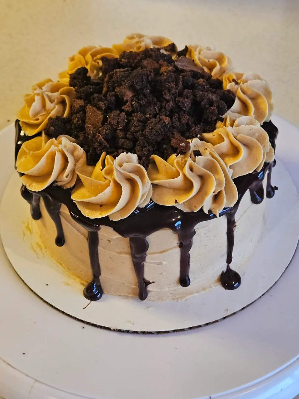 Chocolate drip cake with golden piped frosting and chocolate topping