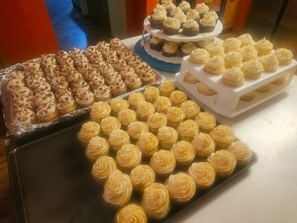 Large party spread of cupcakes with several piped frosting styles