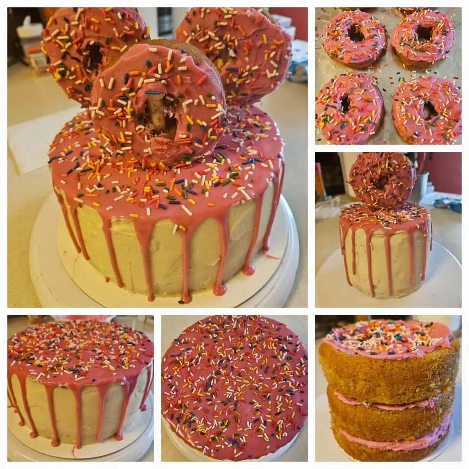 Pink drip cake topped with decorated donuts and sprinkles