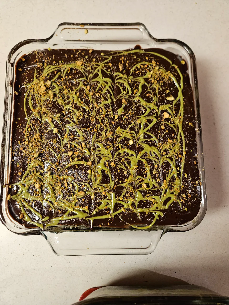 Dubai chocolate brownie with a dark chocolate and pistachio-colored swirl topping