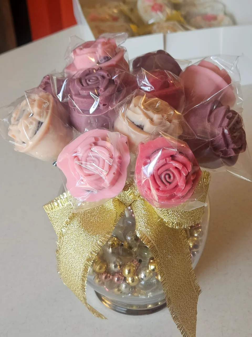 White chocolate-dipped cakesicles decorated with small pink flowers