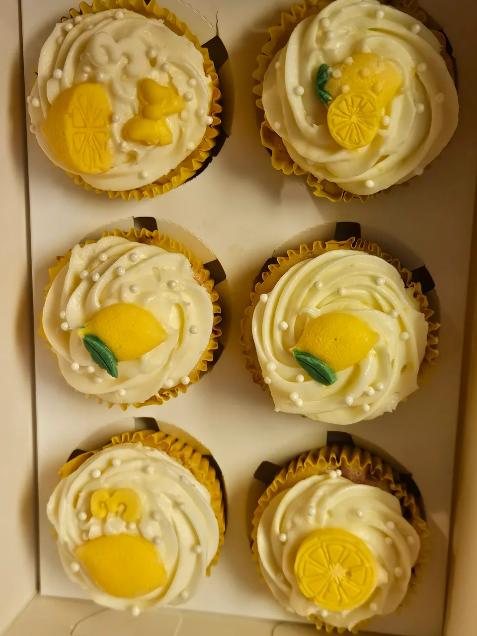 Box of decorated lemon cupcakes
