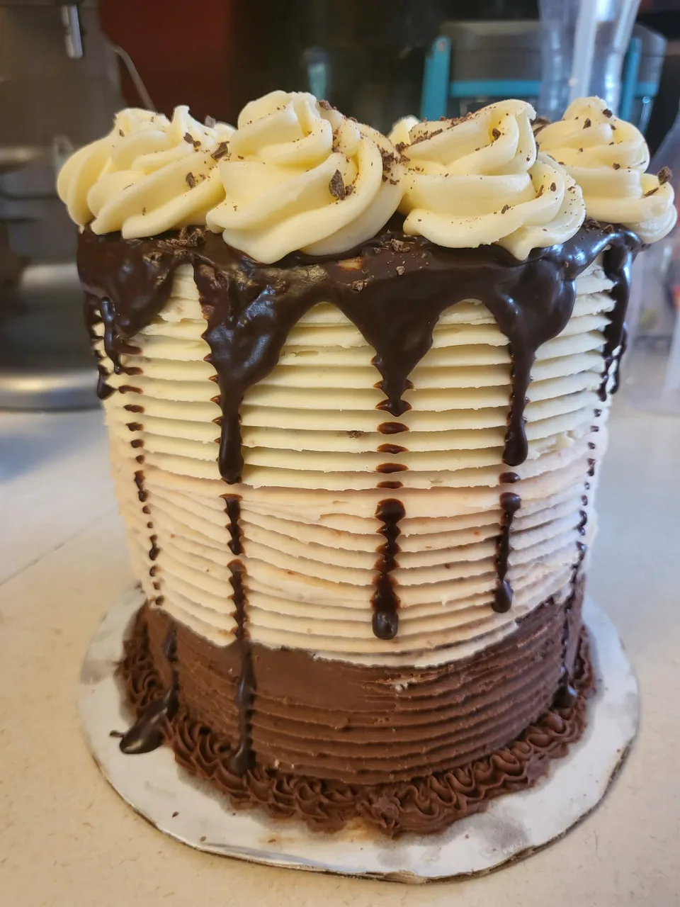 Neapolitan layer cake with cream frosting and chocolate drip