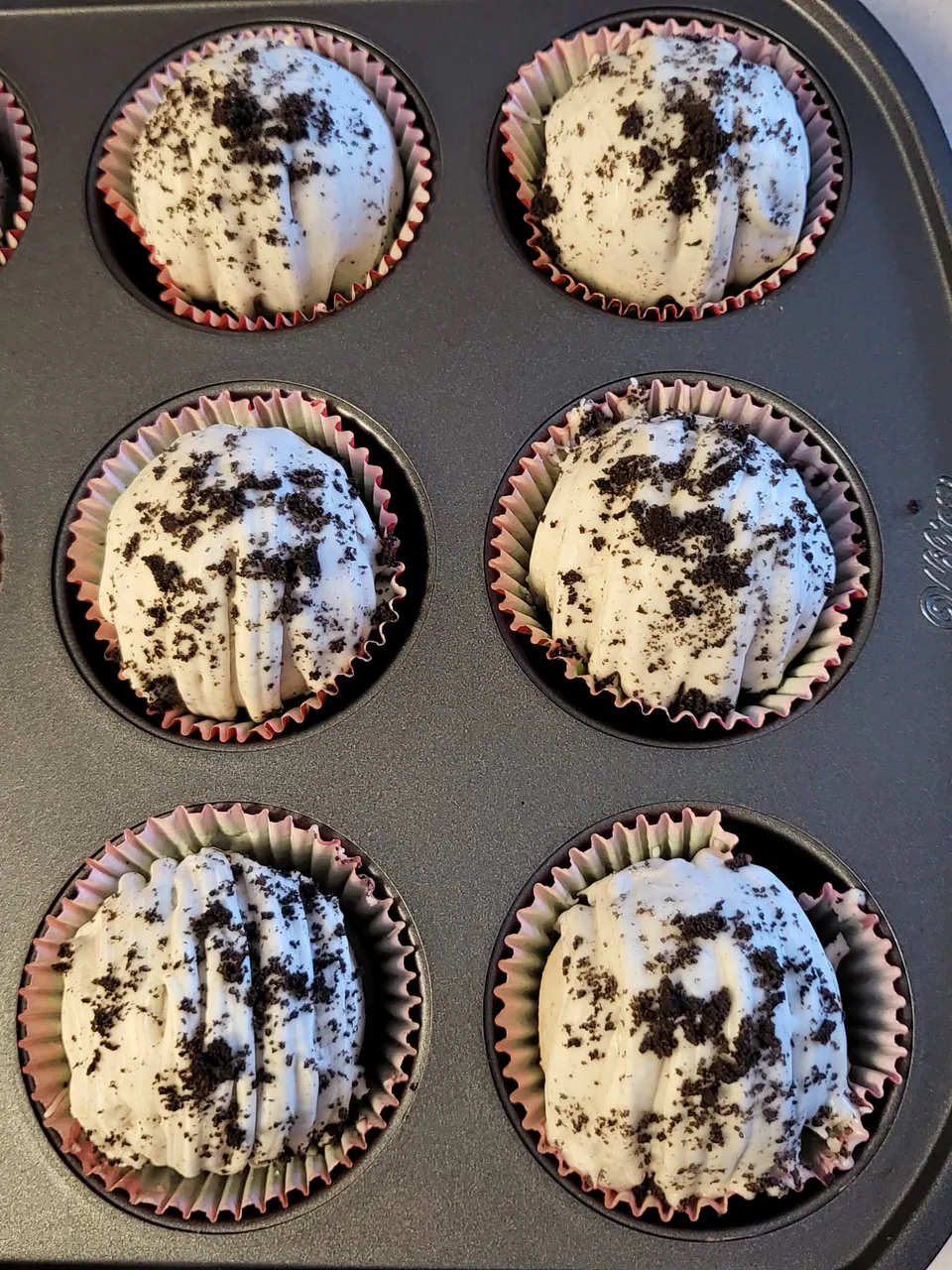 Oreo hot chocolate bombs with white chocolate drizzle and cookie crumbs