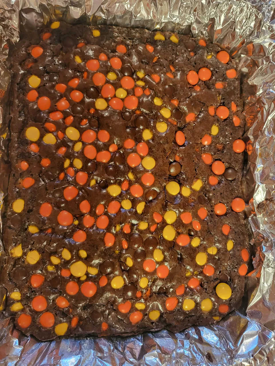 Pan of chocolate brownies topped with peanut butter candy pieces