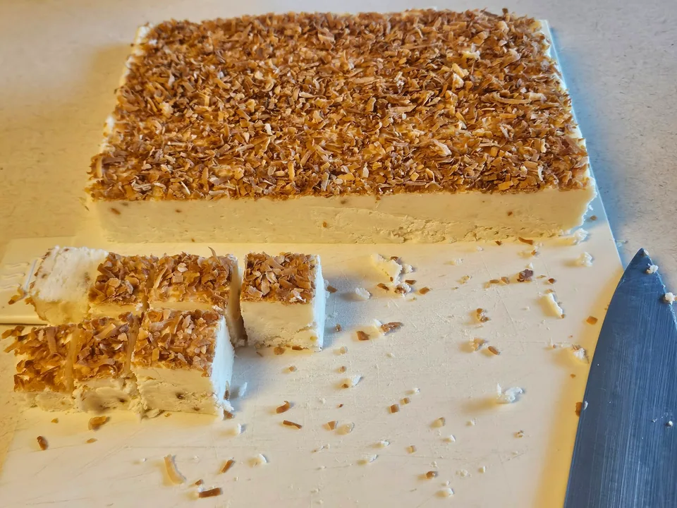 Tray of sliced dessert bars with a pecan topping