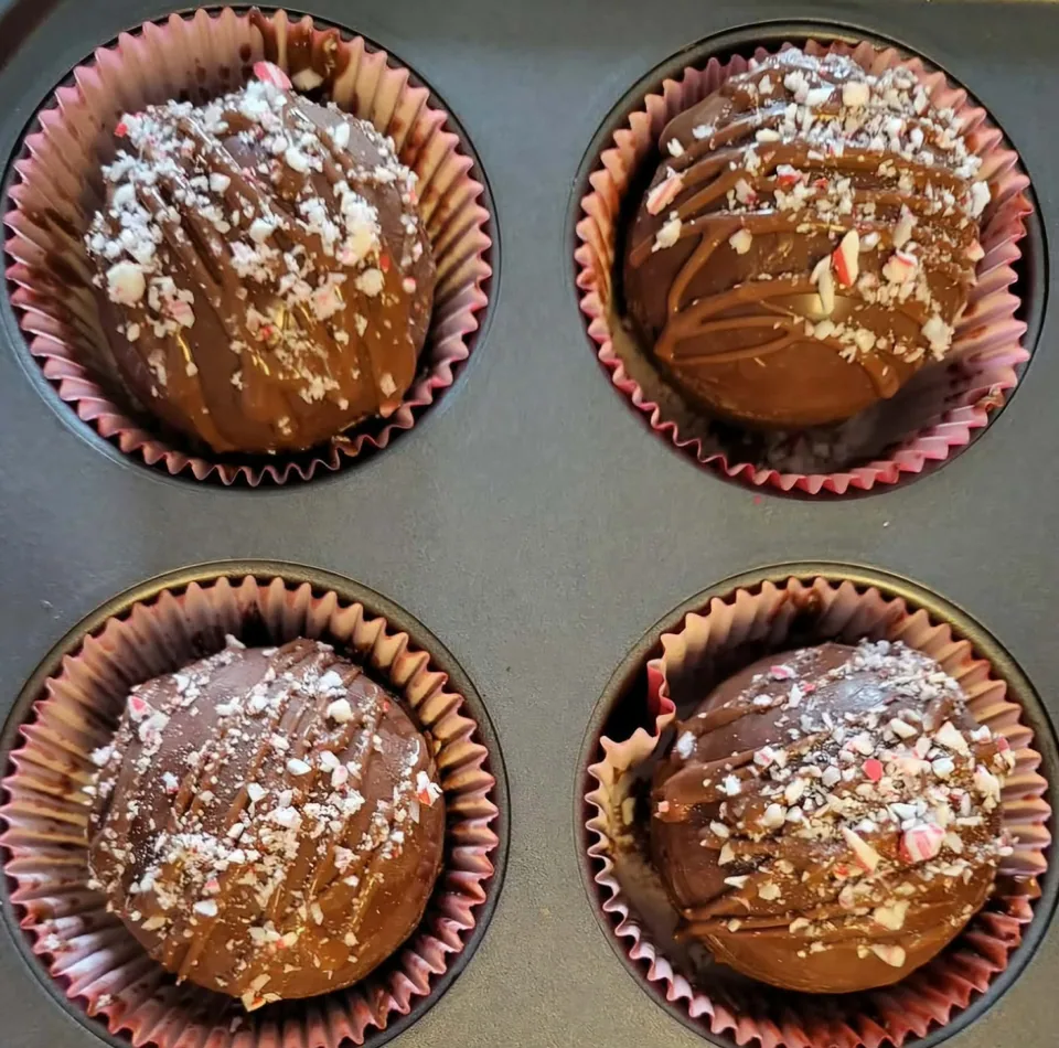 Peppermint hot chocolate bombs with chocolate drizzle and crushed peppermint
