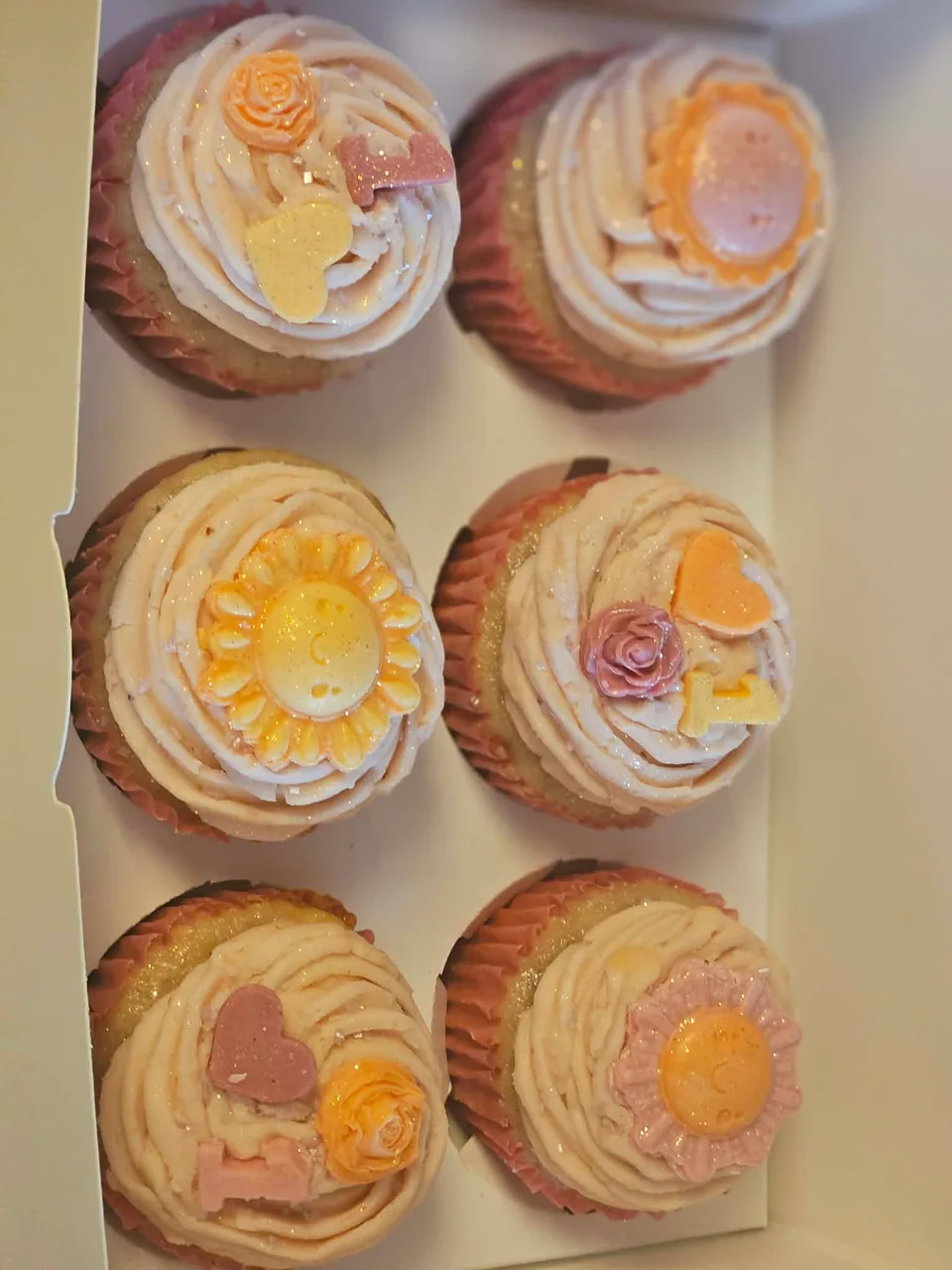Box of pink decorated cupcakes