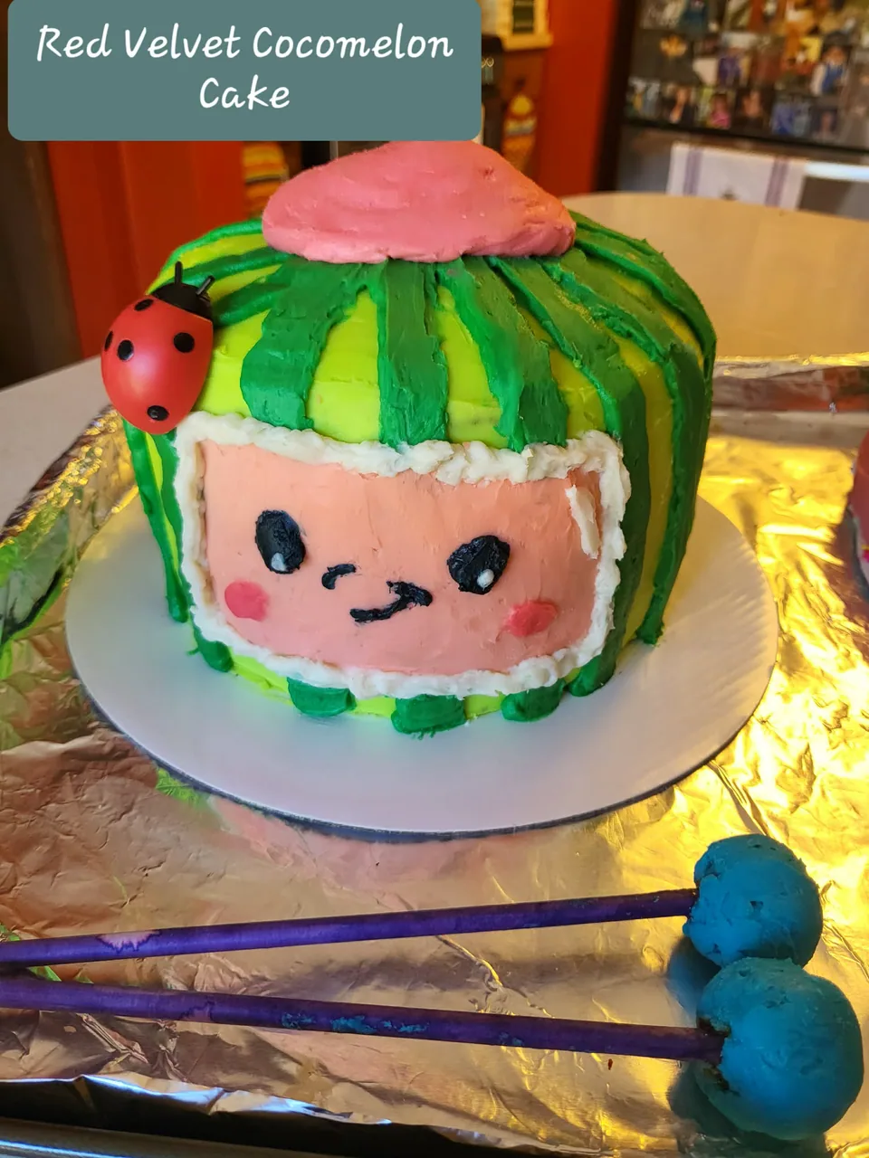 Red velvet Cocomelon-themed cake with colorful fondant details