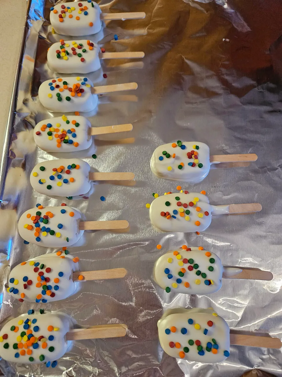White chocolate-dipped cake pops decorated with colorful sprinkles