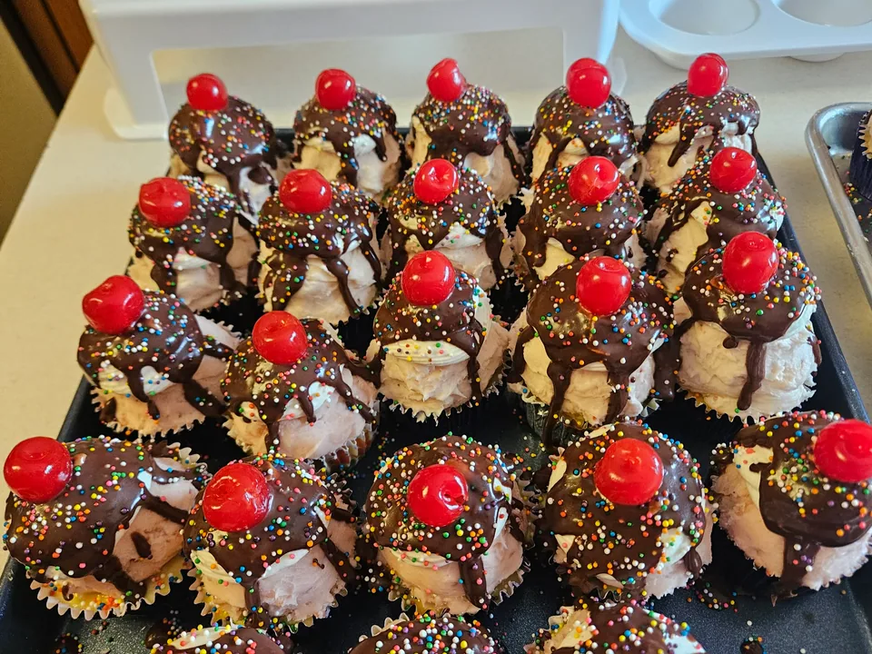 Tray of chocolate sundae cupcakes topped with bright red cherries