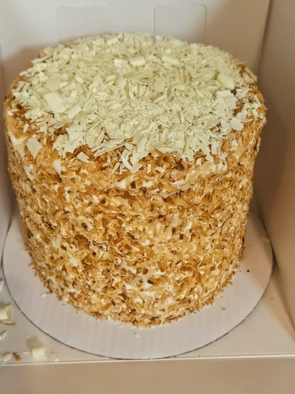 Tall toasted coconut cake covered with coconut flakes
