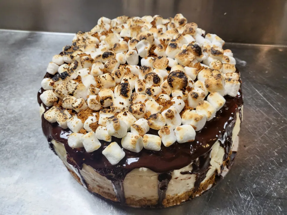 Chocolate drip cake topped with toasted marshmallows
