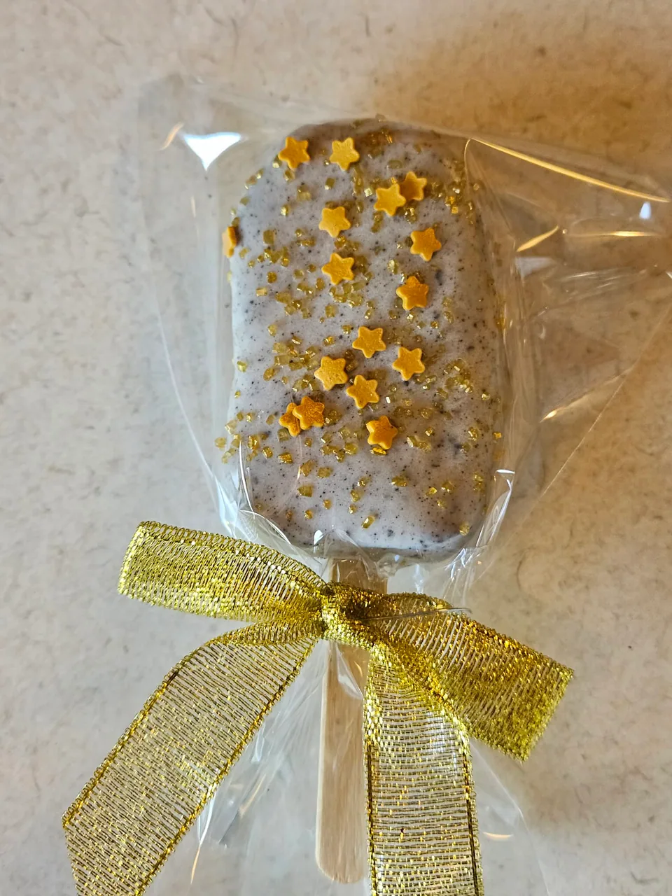 Wrapped white chocolate cake pop with gold star decorations